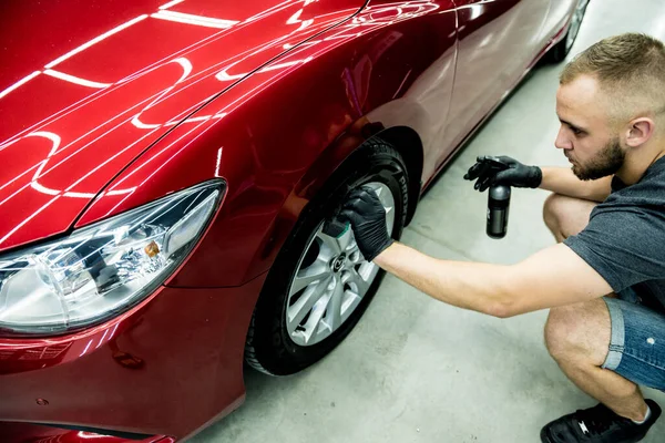 Autoservice-Mitarbeiter poliert Autoräder mit Mikrofasertuch. — Stockfoto