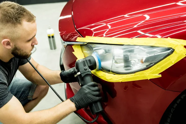 Il lavoratore di servizio d'auto lucida dettagli d'auto con lucidatore orbitale. — Foto Stock