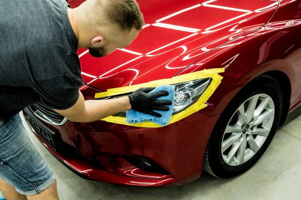 Trabajador de servicio de coches pule los detalles de un coche con pulidor orbital. — Foto de Stock