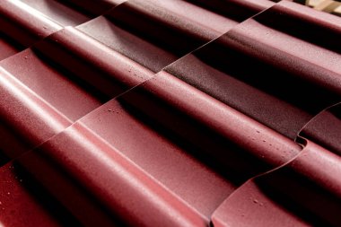 Kırmızı metalik çatı kiremitleri ve su damlaları.