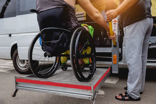 Uomo disabile su sedia a rotelle con veicolo accessibile con meccanismo di sollevamento. — Foto Stock