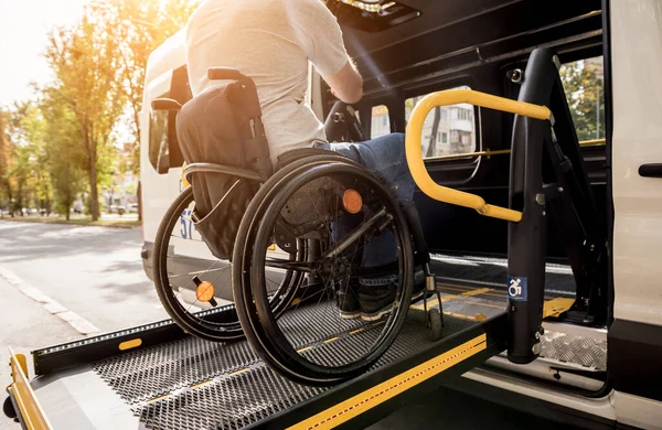 Un hombre en silla de ruedas en un ascensor de un vehículo para personas con discapacidad —  Fotos de Stock