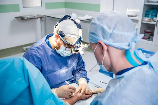 수술실의 외과 의사들은 환자의 손을 구하기 위해. — 스톡 사진