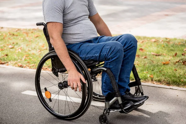 Handicapped man in wheelchair walk at the park alley