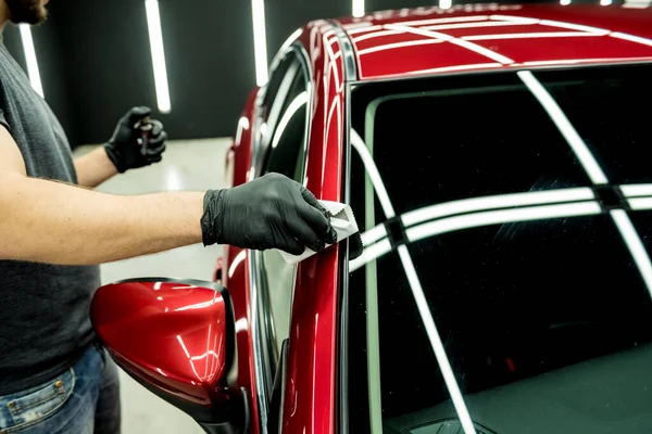 Trabajador de servicio de coches aplicando nano recubrimiento en un detalle del coche. —  Fotos de Stock