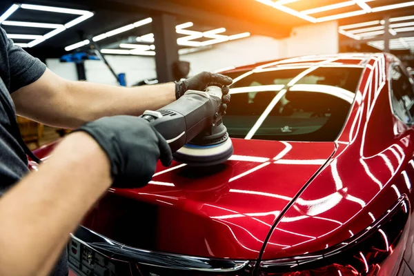 Trabajador de servicio de coches pule los detalles de un coche con pulidor orbital. —  Fotos de Stock