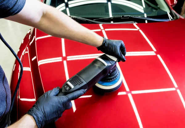 Trabajador de servicio de coches pule los detalles de un coche con pulidor orbital. —  Fotos de Stock