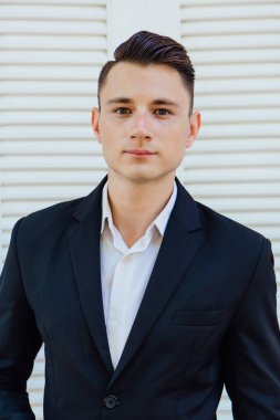 Beyaz arka planda siyah elbiseli yakışıklı adam portresi