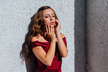 Uzun kırmızı gece elbisesi ayakta duvar eski yanında güzel genç kadın