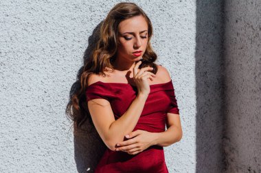 Uzun kırmızı gece elbisesi ayakta duvar eski yanında güzel genç kadın