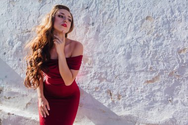 Uzun kırmızı gece elbisesi ayakta duvar eski yanında güzel ve genç birbayan. Kopya alanı.