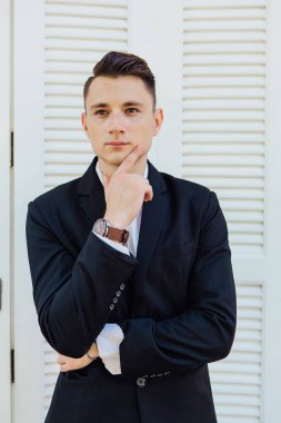 Beyaz arka planda siyah elbiseli yakışıklı adam portresi