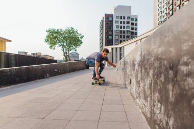 Sokakta longboard sürme sakallı genç yakışıklı adam.