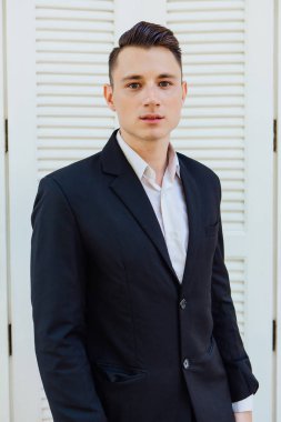 Beyaz arka planda siyah elbiseli yakışıklı adam portresi