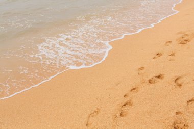 Tropik ada ve ayak beyaz köpük mavi deniz kum üzerine yazdırır