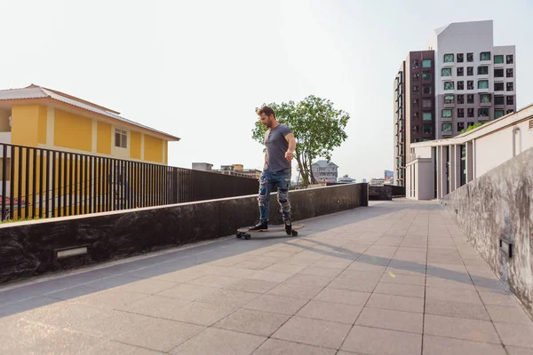 ストリートでスケートボードに乗っている若い男は. — ストック写真