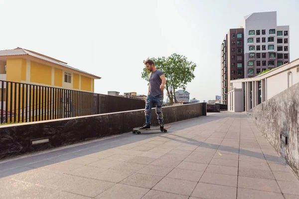 Joven hombre montando monopatín en la calle. — Foto de Stock