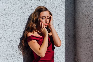 Uzun kırmızı gece elbisesi ayakta duvar eski yanında güzel genç kadın