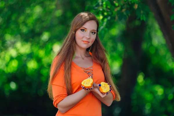 Retrato Una Bonita Mujer Pelirroja Sosteniendo Dos Mitades Jugosas Naranjas —  Fotos de Stock