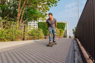 Sokakta longboard sürme sakallı genç yakışıklı adam.