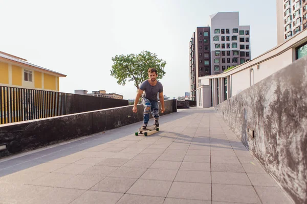 Sokakta longboard sürme sakallı genç yakışıklı adam.