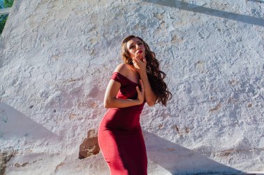 Uzun kırmızı gece elbisesi ayakta duvar eski yanında güzel ve genç birbayan. Kopya alanı.