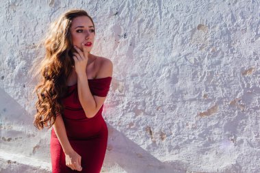 Uzun kırmızı gece elbisesi ayakta duvar eski yanında güzel ve genç birbayan. Kopya alanı.