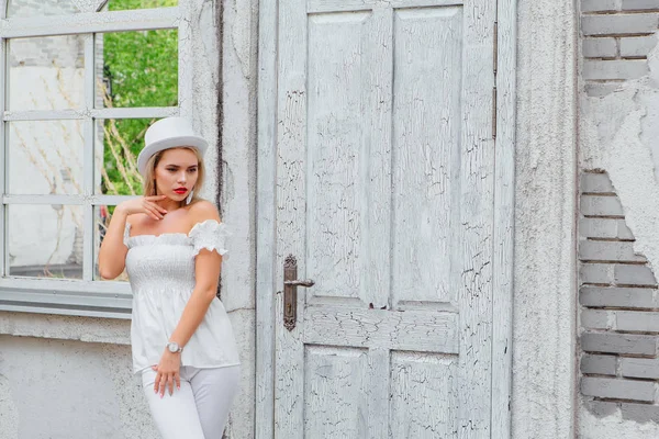 Beyaz silindir şapka lstanding eski beyaz vintage kapı ve ayna pencere yanında seksi modern gelin. Kopya alanı.