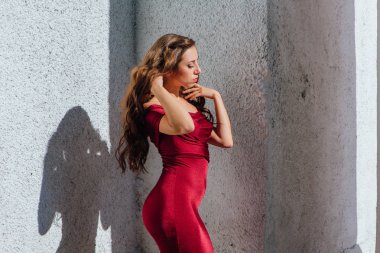 Güzel genç kadın yanındaki duvar eski bir tren konumu olan bir uzun kırmızı gece elbisesi
