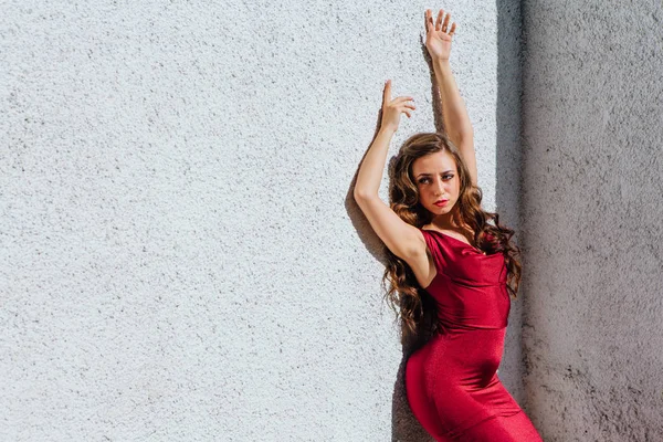 Uzun kırmızı gece elbisesi ayakta duvar eski yanında güzel ve genç birbayan. Kopya alanı.