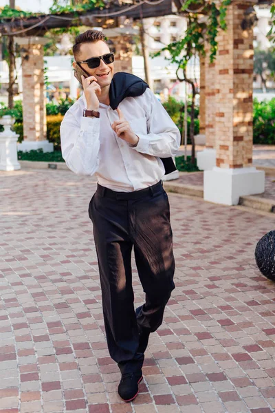 Genç işadamı telefonunu açık havada tropikal bir ülkede konuşurken