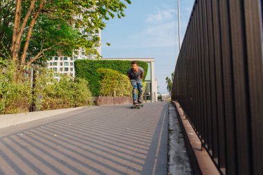 Sokakta longboard sürme sakallı genç yakışıklı adam.