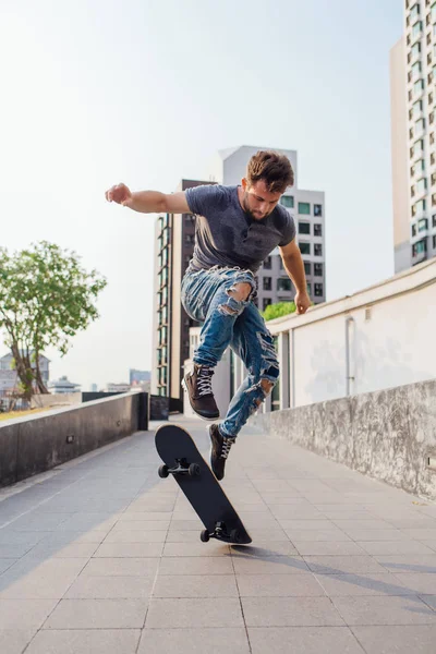 Skateboarder doing a skateboard trick ollie on the street of a city