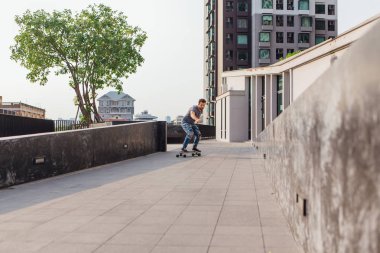 Sokakta longboard sürme sakallı genç yakışıklı adam.