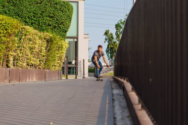 Sokakta longboard sürme sakallı genç yakışıklı adam.