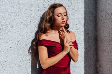 Uzun kırmızı gece elbisesi ayakta duvar eski yanında güzel genç kadın