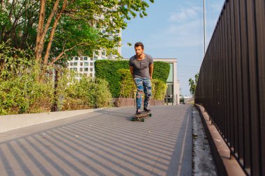 Sokakta longboard sürme sakallı genç yakışıklı adam.