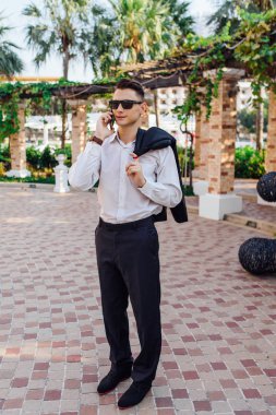 Genç işadamı telefonunu açık havada tropikal bir ülkede konuşurken