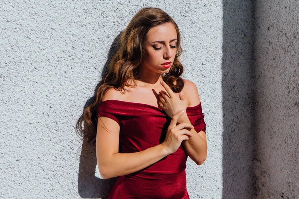 Uzun kırmızı gece elbisesi ayakta duvar eski yanında güzel genç kadın
