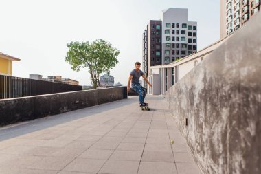 Sokakta longboard sürme sakallı genç yakışıklı adam.