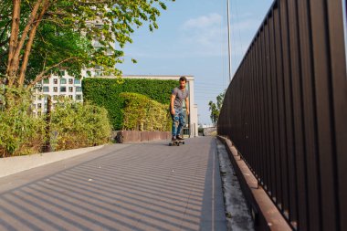 Sokakta longboard sürme sakallı genç yakışıklı adam.