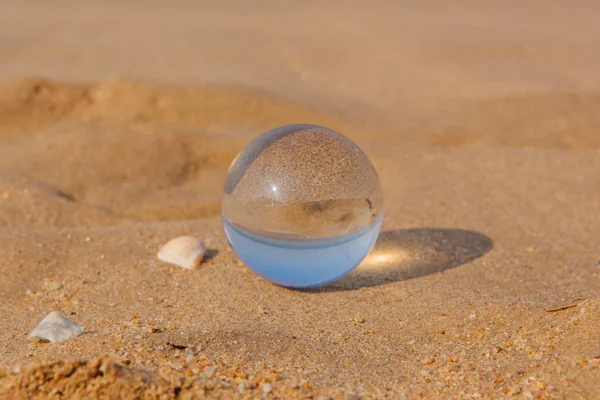 Lens bal op de zand textuur van het strand — Stockfoto