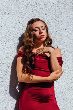 Uzun kırmızı gece elbisesi ayakta duvar eski yanında güzel genç kadın