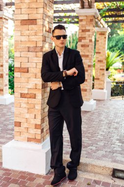 Takım ve güneş gözlüğü modern kent park, poz şık yakışıklı delikanlı.