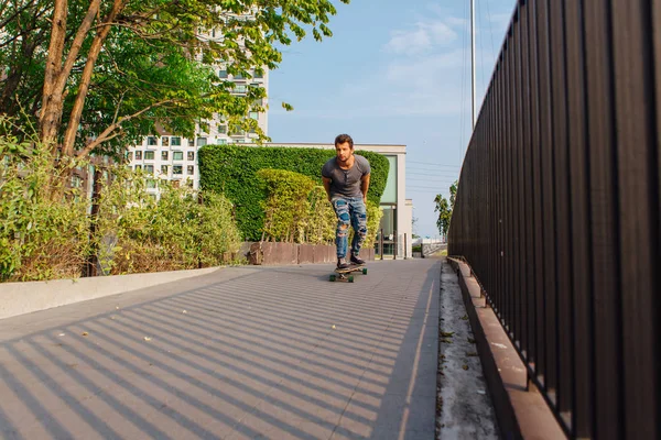 Sokakta longboard sürme sakallı genç yakışıklı adam.