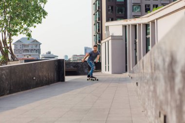 Sokakta longboard sürme sakallı genç yakışıklı adam.