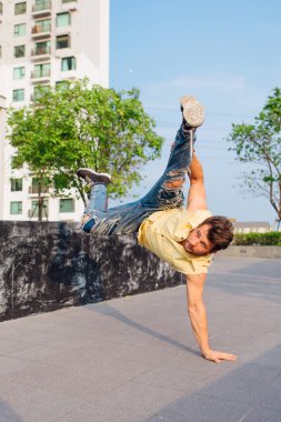 Breakdance sokakta dans sakallı genç yakışıklı adam. Adam ellerinde standları.