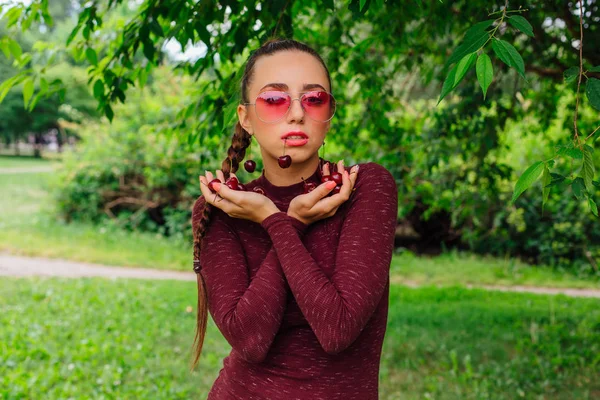 Красива Молода Жінка Довгими Косами Рожевими Окулярами Вишневими Сережками Тримають — стокове фото