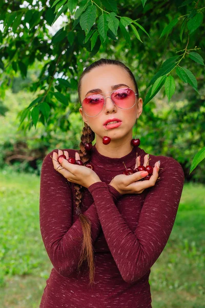 Красива Молода Жінка Довгими Косами Рожевими Окулярами Вишневими Сережками Тримають — стокове фото