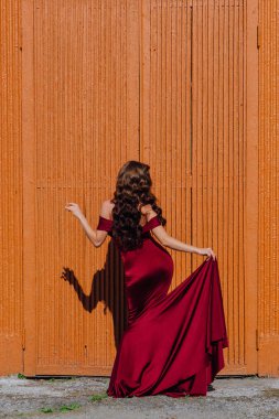 Eski kapı yanındaki bir tren konumu olan bir uzun kırmızı gece elbisesi güzel genç kadın